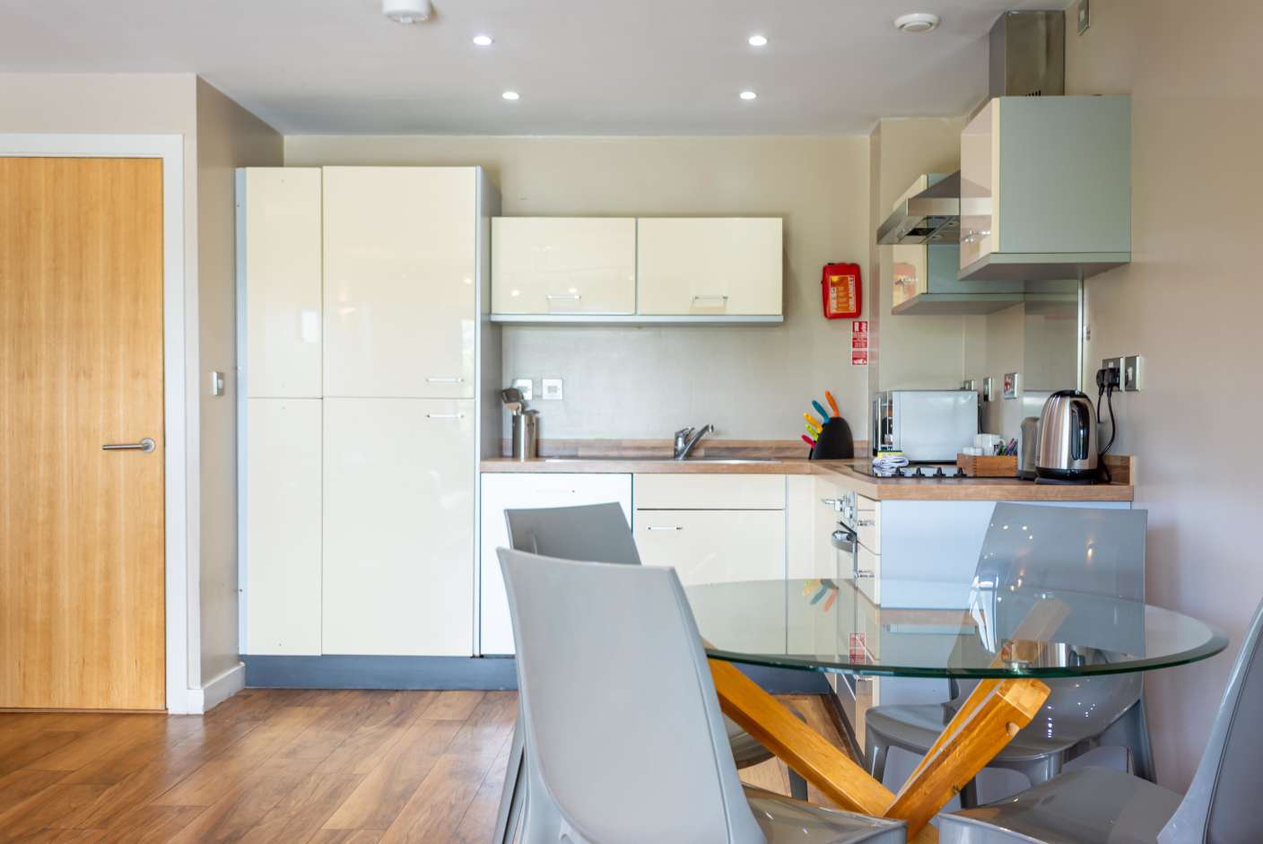 Kitchen with full oven, microwave, cream units, dishwasher and dining table. 